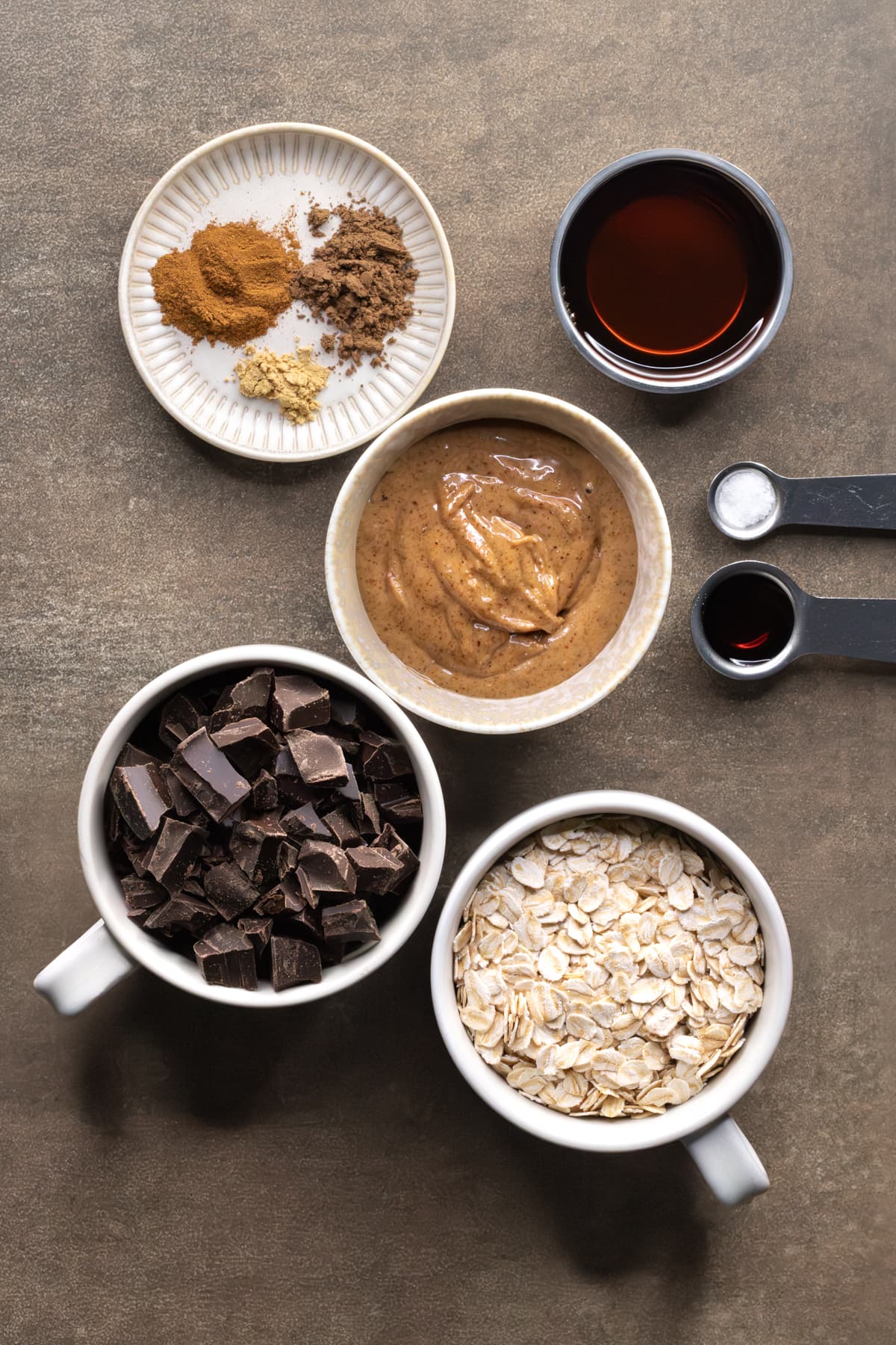 Ingredients for spiced chocolate almond butter Easter eggs set out in bowls and cups