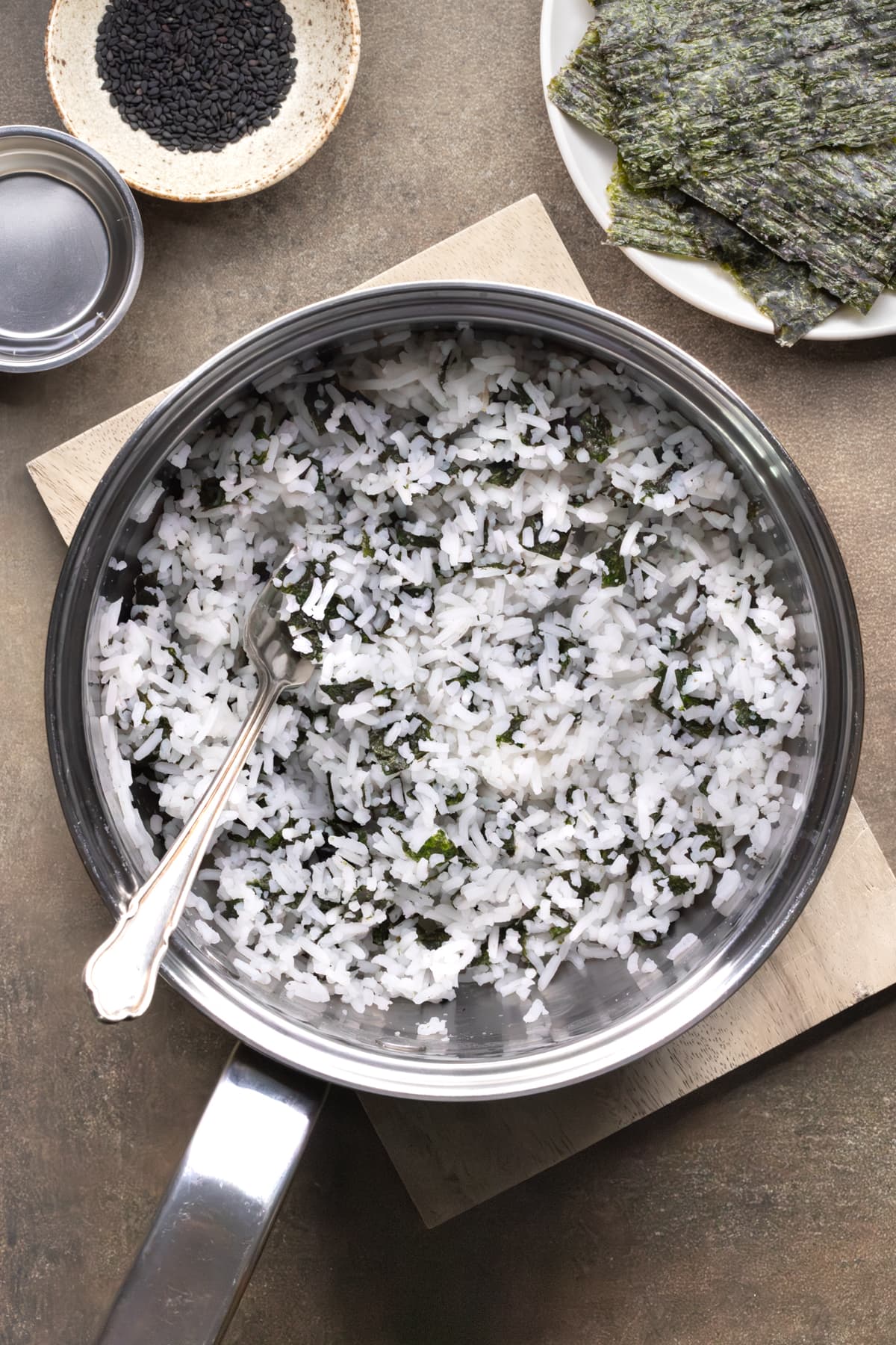 Cooked white rice mixed with small pieces of nori in a saucepan