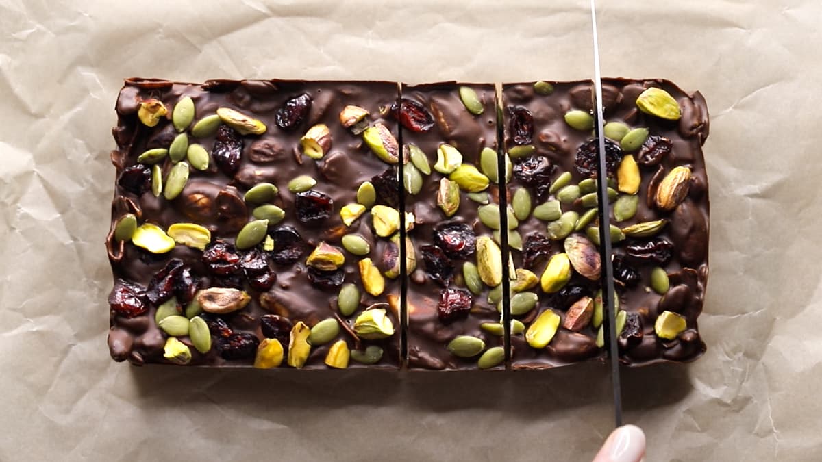 Dark chocolate rocky road slab being sliced into bars