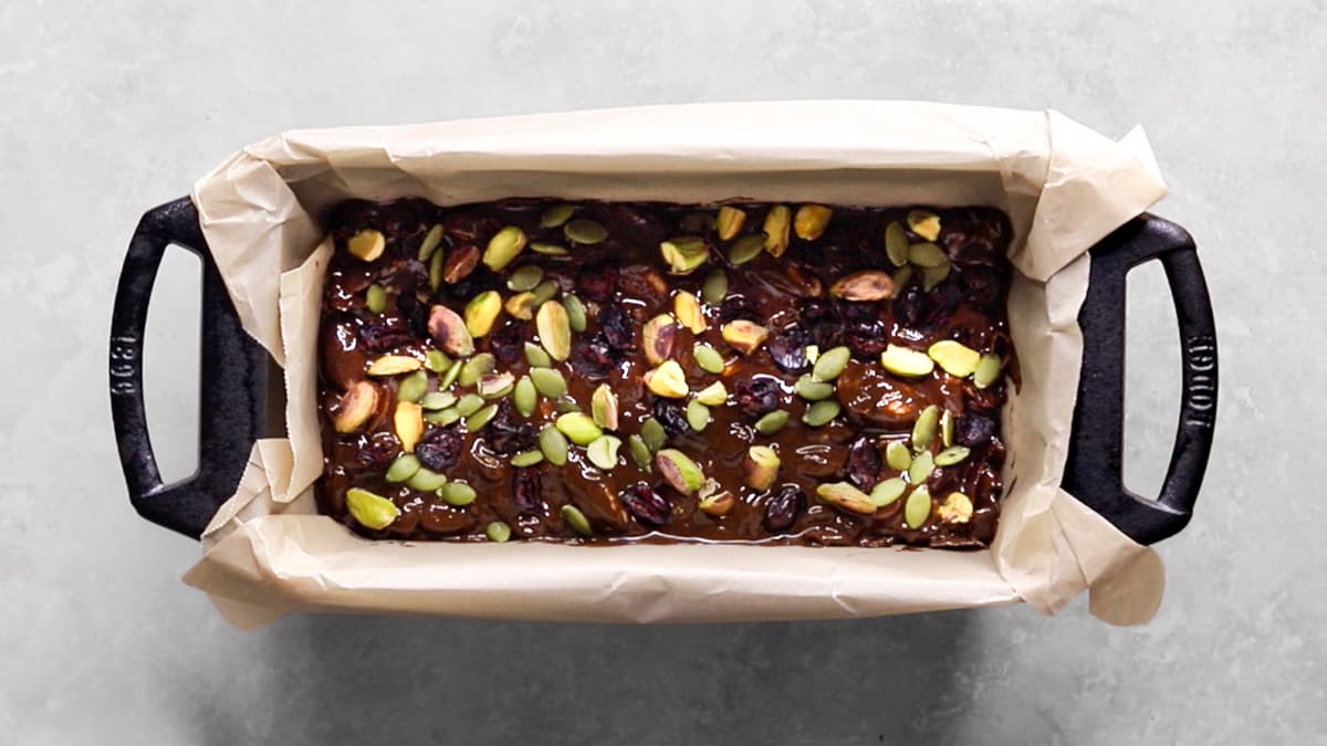 Rocky road mixture spread evenly in a parchment-lined loaf pan before chilling