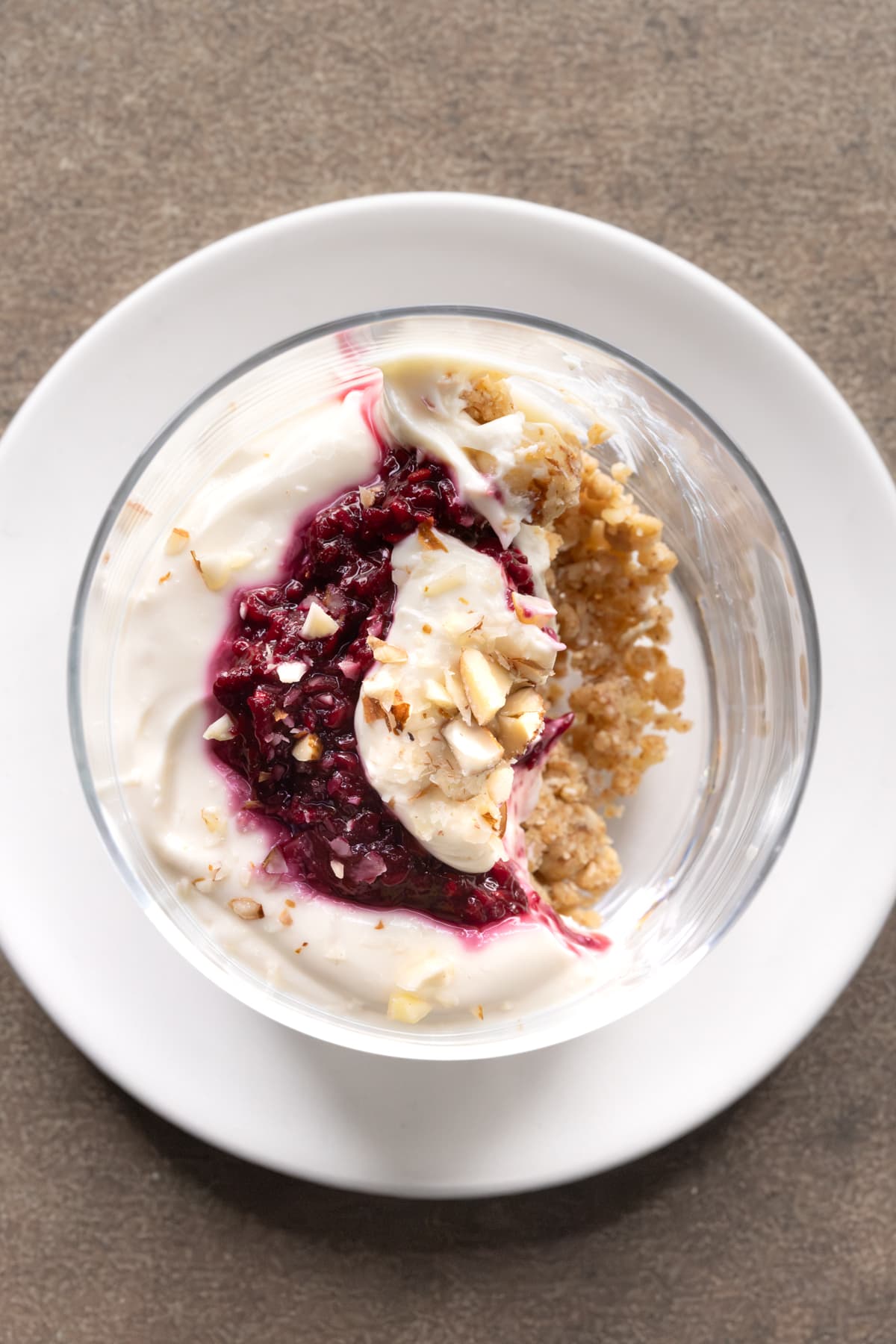 Partially eaten no-bake cheesecake cup showing layers of cheesecake filling and raspberry compote