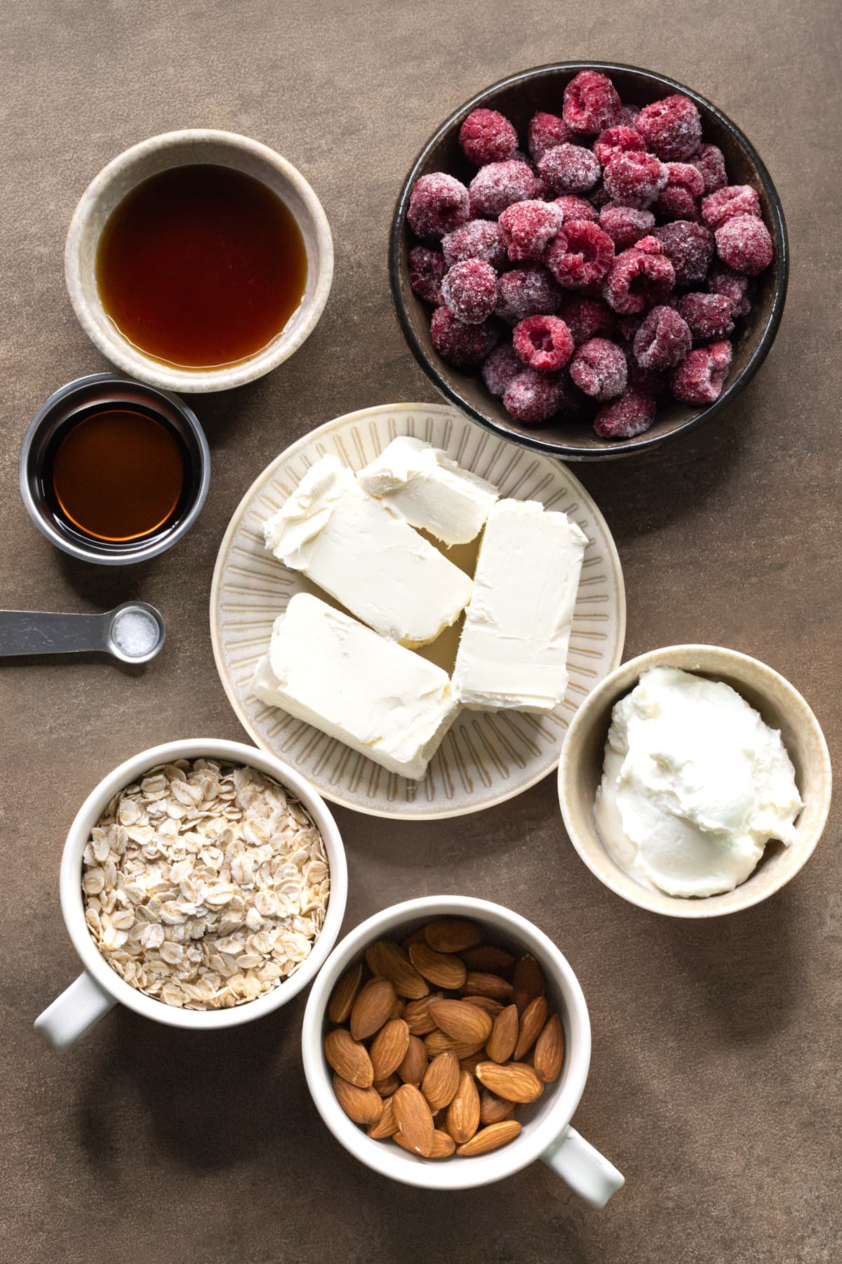 Ingredients for no-bake cheesecake cups set out on plates and in bowls