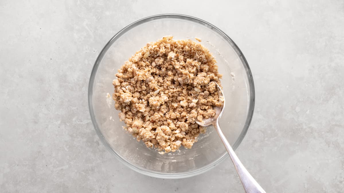 Oat and almond crumble mixture in a bowl with a spoon