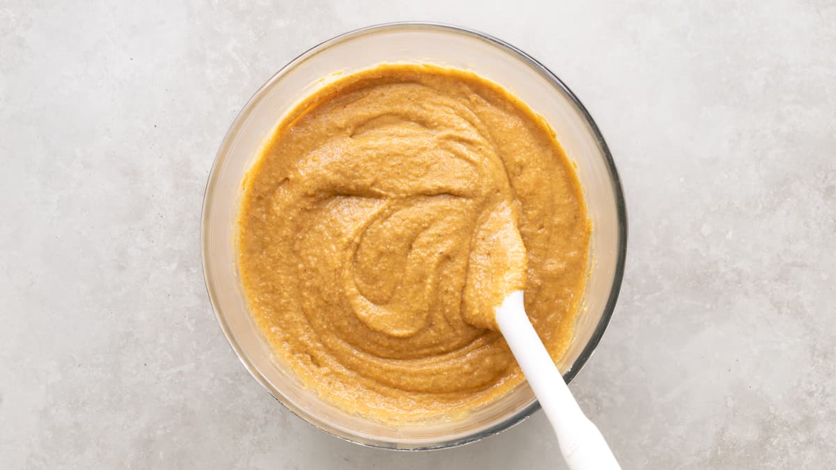 Pumpkin oatmeal muffin batter mixed in a bowl with a spatula